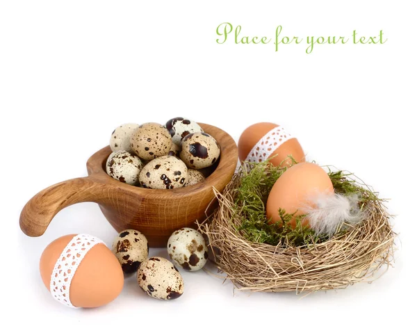 Easter eggs in a nest and a wooden plate on a white background. Easter background. — Stock Photo, Image