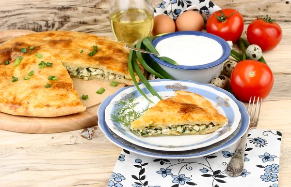 Taze pişmiş ev pasta yumurta ve yeşil soğan o Ayrıca bir retro uzak süpürüldü bir doldurma ile bir rustik bir arka plan üzerinde ahşap plakalar.
