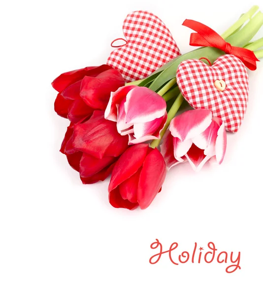 Ramo de tulipanes frescos y 2 corazones textiles sobre un fondo blanco . — Foto de Stock