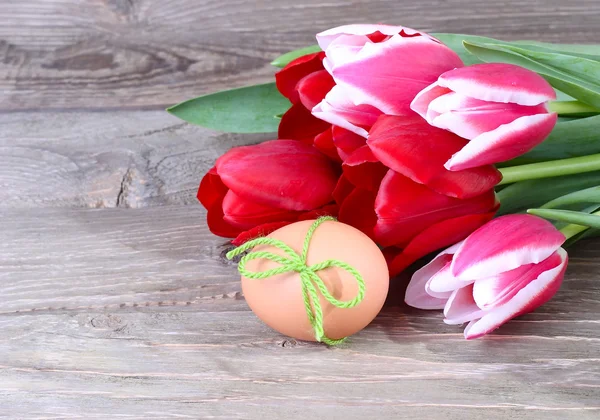 Bouquet of fresh tulips, Easter egg and wooden chicken on wooden a rustic a background. Easter background. — Stock Photo, Image
