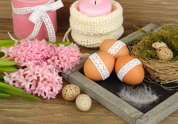 Pink hyacinths and Easter eggs on a blackboard (a cretaceous board) on wooden a rustic a background. Easter background. — Stock Photo, Image