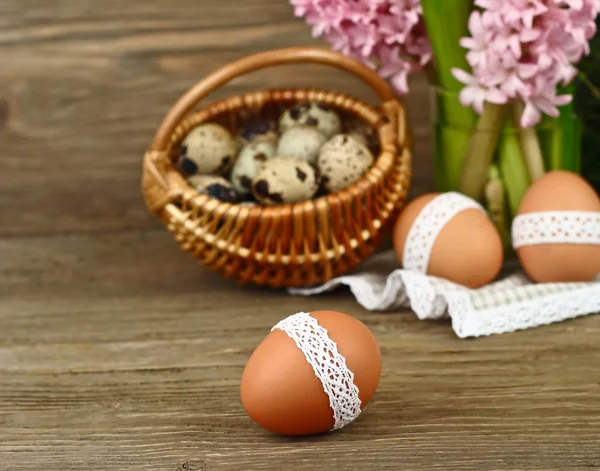 Los huevos de Pascua con la cinta de algodón a la madera el fondo rústico. Fondo de Pascua . —  Fotos de Stock