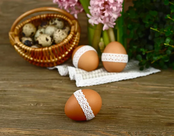 Пасхальные яйца с хлопковой лентой на деревянном деревенском фоне. Пасхальный фон . — стоковое фото
