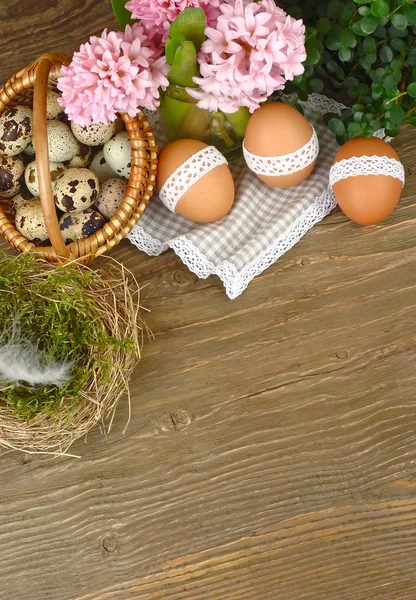 Los huevos de Pascua con la cinta de algodón a la madera el fondo rústico. Fondo de Pascua . —  Fotos de Stock