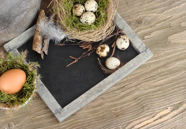 Velikonoční vejce na křídové tabuli (tabule) na dřevěné rustikální pozadí. Velikonoční pozadí. — Stock fotografie