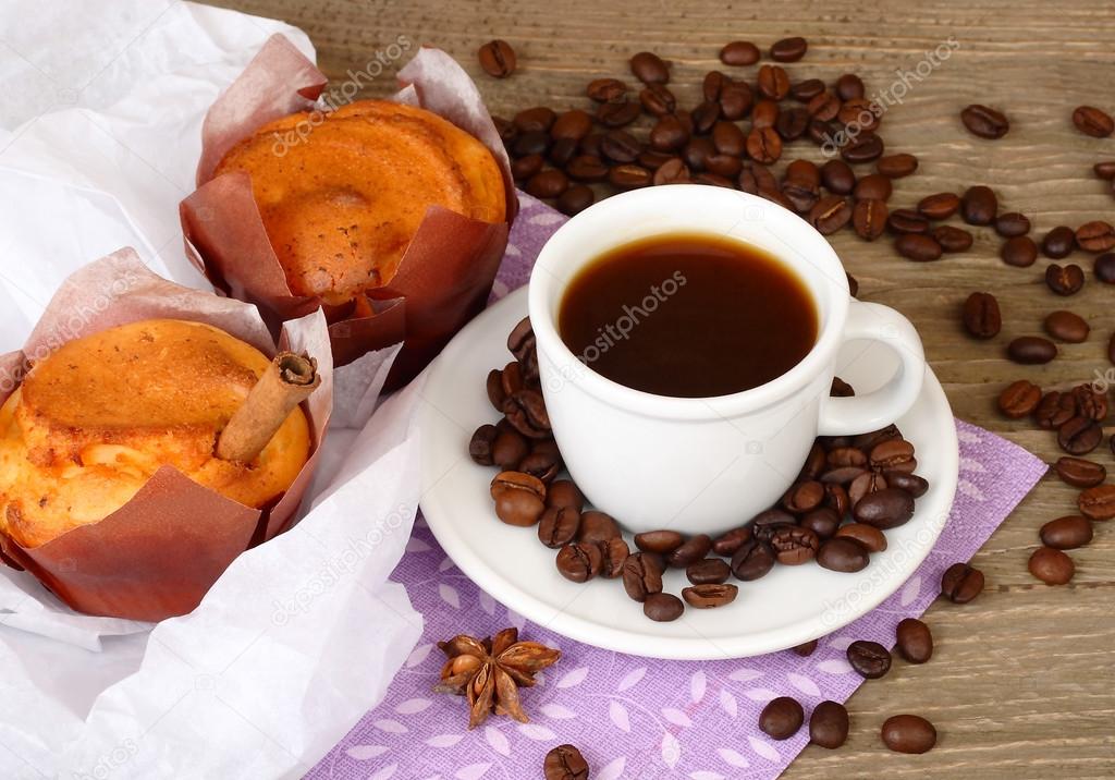 Cup of coffee and fragrant fresh house cakes on a wooden background.