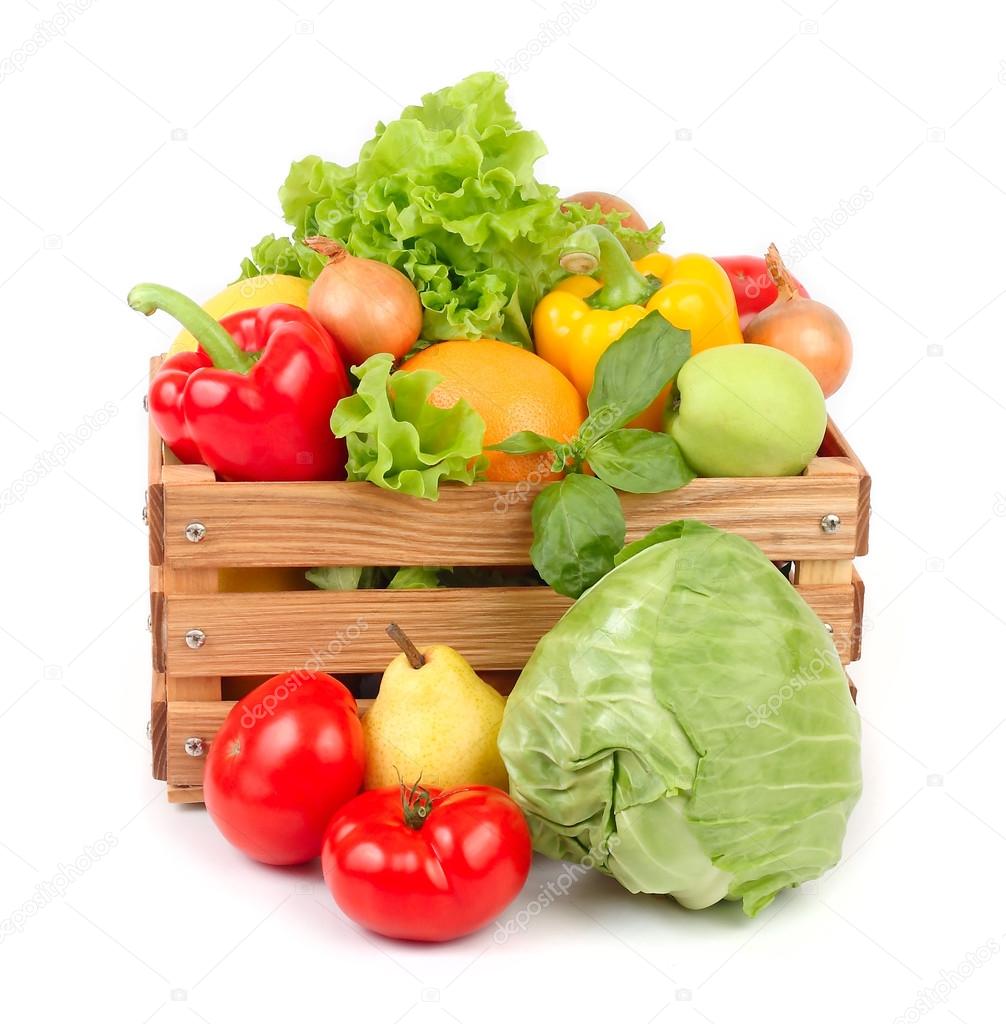 Fresh vegetables and fruit in a wooden box on a white background.