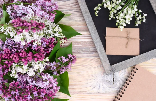 Blume hölzernen Hintergrund mit einem Flieder und einer Kreidetafel mit einem Platz für den Text. Ansicht von oben. — Stockfoto