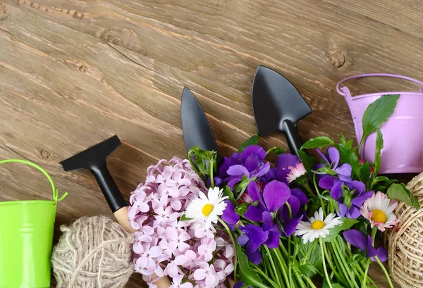 Tools for work in a garden and with houseplants on a wooden background. Top view. — Stock Photo, Image