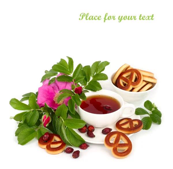 Tee mit Heckenrose, Blumen und Hüften auf weißem Hintergrund. — Stockfoto