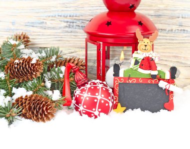 Noel kompozisyon kırmızı bir lamba, Kretase kurula bir geyik ve ahşap arka plan üzerinde kırmızı bir Noel top ile. Bir Noel arka plan metni için bir yer ile.