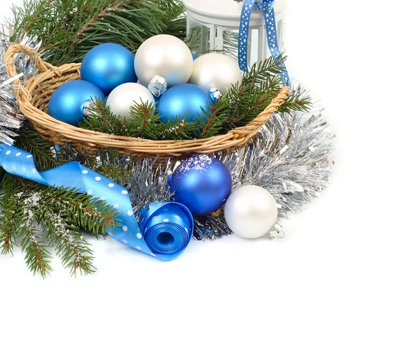 Blue and white Christmas balls in korizine silvery tinsel on a white background. Christmas composition with blue Christmas balls, cones and silvery snowflakes on a blue background. A Christmas background with a place for the text.