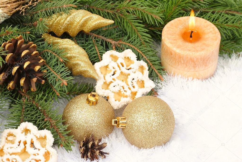 Golden Christmas balls and cones and cookies in the form of snowflakes on decorative snow on a white background. Christmas background.