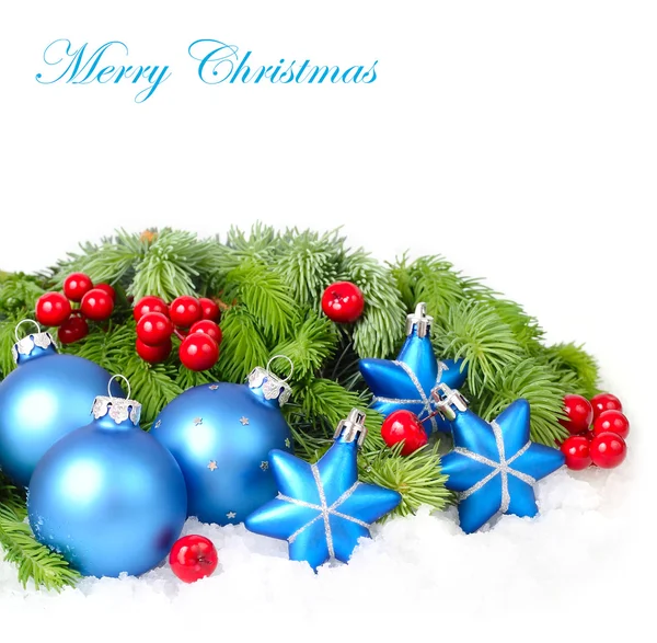 Blue Christmas balls and stars and red berries on branches of a Christmas tree on a white background. A Christmas background with a place for the text. — Stock Photo, Image