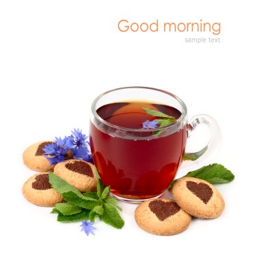 Transparent glass cup of black tea with mint and cornflowers and round shortcake with hearts on a white background. clipart