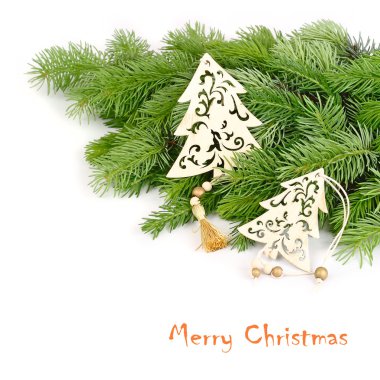 Wooden openwork fir-trees on fluffy branches of a Christmas tree on a white background. A Christmas background with a place for the text.