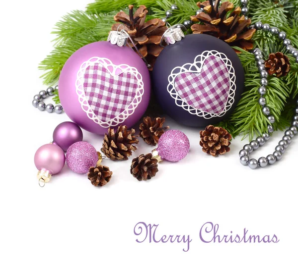 Violet Christmas balls with heart and cones on branches of a Christmas tree on a white background. A Christmas background with a place for the text. — Stock Photo, Image