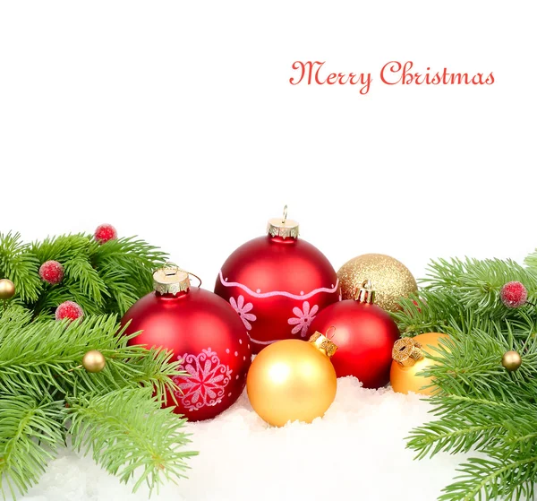 Red and golden Christmas balls and branches of a Christmas tree on snow on a white background. A Christmas background with a place for the text. — Stock fotografie