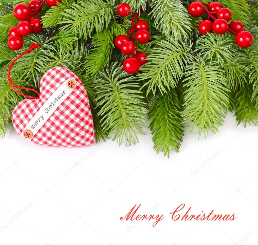 Fluffy branches of a Christmas tree, textile heart and red berries on a white background. A Christmas background with a place for the text.