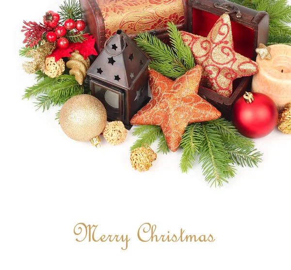 Golden stars in wooden chests, candles and other Christmas-tree decorations on branches of a Christmas tree on a white background.