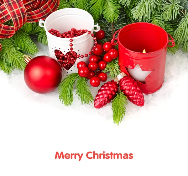 Kırmızı ve beyaz şamdanlar, Noel top ve koniler beyaz zemin üzerinde bir Noel ağacının dalları üzerinde. Bir Noel arka plan metni için bir yer ile.