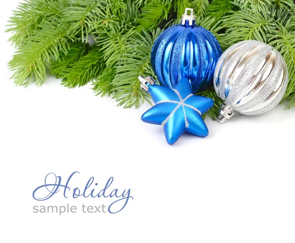 Blue and silvery Christmas balls and blue star on fluffy branches of a Christmas tree on a white background. A Christmas background with a place for the text. — Stock Photo, Image