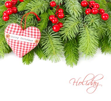 Kırmızı meyveler ve kırmızı kareli Tekstil kalp üzerinde kabarık beyaz zemin üzerinde bir Noel ağacı dalı. Bir Noel arka plan metni için bir yer ile.