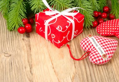 Kırmızı hediye kutusu, kırmızı meyveler ve ahşap arka plan üzerinde kırmızı kareli Tekstil kalp. Bir Noel arka plan metni için bir yer ile.