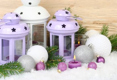 Menekşe şamdanlar - lambalar ve mor ve beyaz Noel topları üzerinde kar beyaz bir arka plan üzerinde. Bir Noel arka plan metni için bir yer ile.