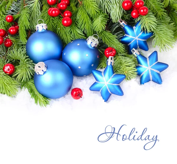 蓝色圣诞球，星星和蓬松分支的白色背景上的一棵圣诞树上的红色浆果。圣诞节背景以及放置文本的位置. 图库图片