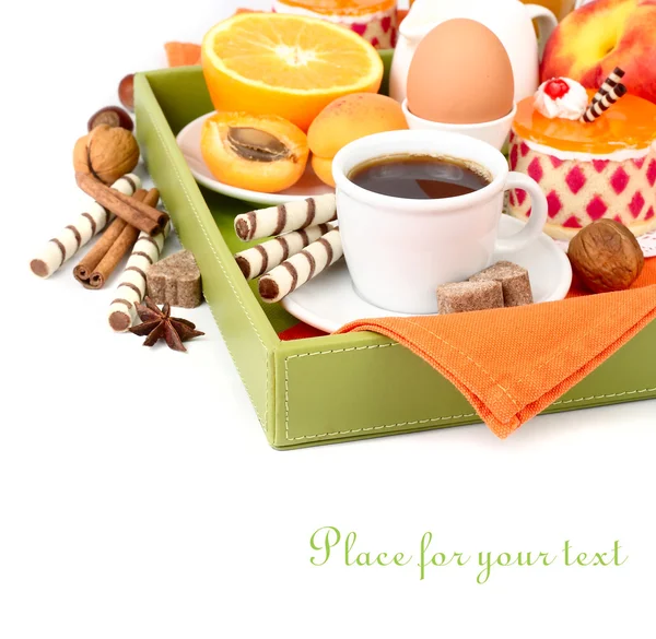 Frühstück für jeden Geschmack in einem Tablett: Kaffee, Obst, Saft, gekochtes Ei, Kuchen und Waffelröhrchen auf weißem Hintergrund mit Platz für den Text. — Stockfoto