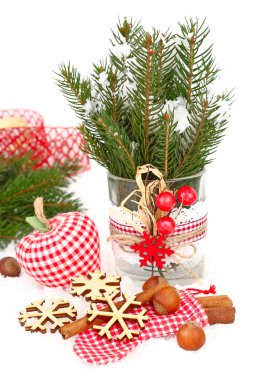 Textile checkered Christmas jewelry, wooden snowflakes and nuts on snow on a white background. A Christmas background with a place for the text.