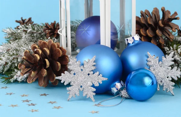 Composición navideña con bolas azules de Navidad, conos y copos de nieve plateados sobre un fondo azul. Un fondo navideño con un lugar para el texto . — Foto de Stock