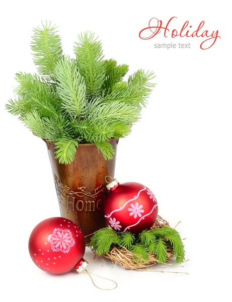 Dekorativer Eimer mit Zweigen eines Weihnachtsbaums und Weihnachtskugeln auf weißem Hintergrund. ein weihnachtlicher Hintergrund mit einem Platz für den Text. — Stockfoto