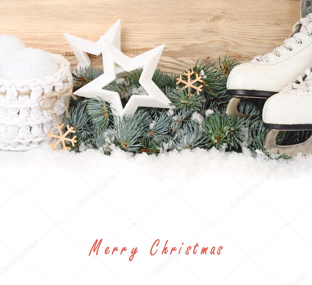 The skates, stars and white Christmas balls on branches of a snow-covered Christmas tree on a white background. A Christmas background with a place for the text.