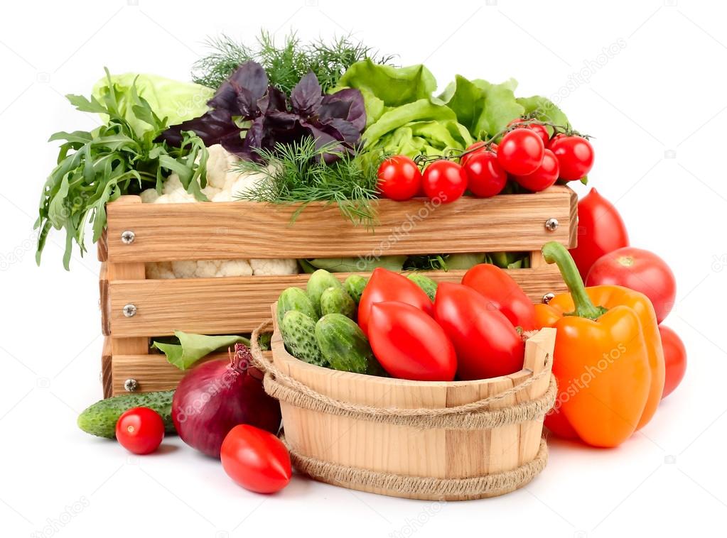 Fresh ripe vegetables in a wooden box on a white background with a place for the text.