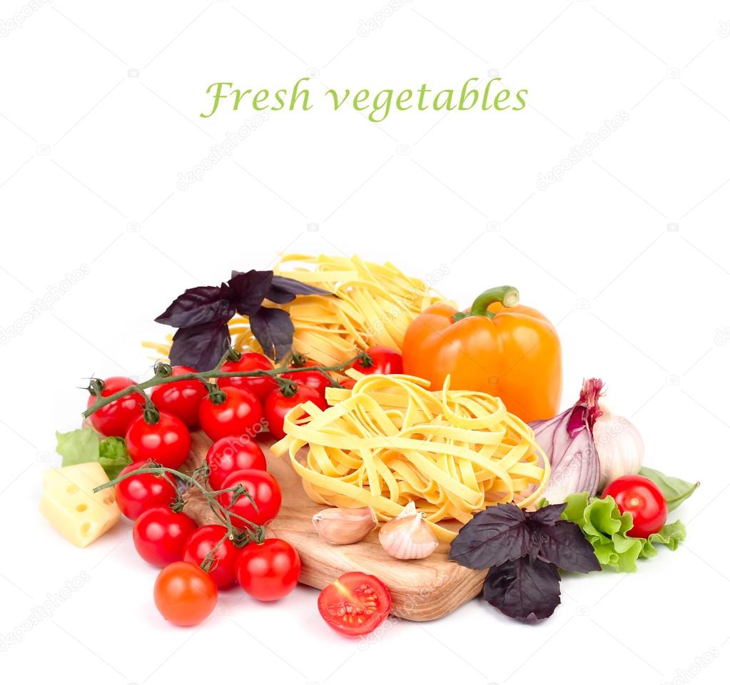 Pasta and fresh vegetables on a kitchen chopping board on a white background with a place for the text.