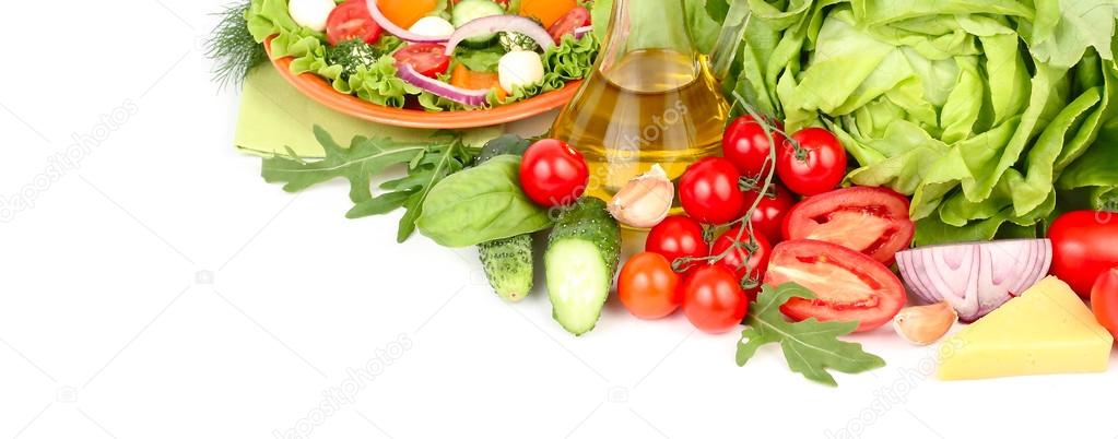 Fresh ripe vegetables and herbs and the Greek salad with cheese balls on an orange plate and on a white background with a place for the text.