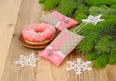 İşlemeli pembe kardan adam ve ahşap arka plan üzerinde bir Noel ağacının dalları üzerinde örme kar taneleri ile tekstil yılbaşı ağacı süsleri. Bir Noel arka plan metni için bir yer ile.