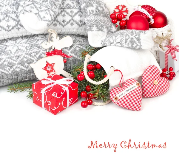 Composición navideña con corazones rojos textiles, una caja de regalo roja y decoraciones de árbol de Navidad al estilo escandinavo sobre fondo blanco. Un fondo navideño con un lugar para el texto . — Foto de Stock