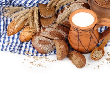 Taze ekmek ve süt metni için bir yer beyaz bir zemin üzerine mavi kareli peçeteye ile sürahi.