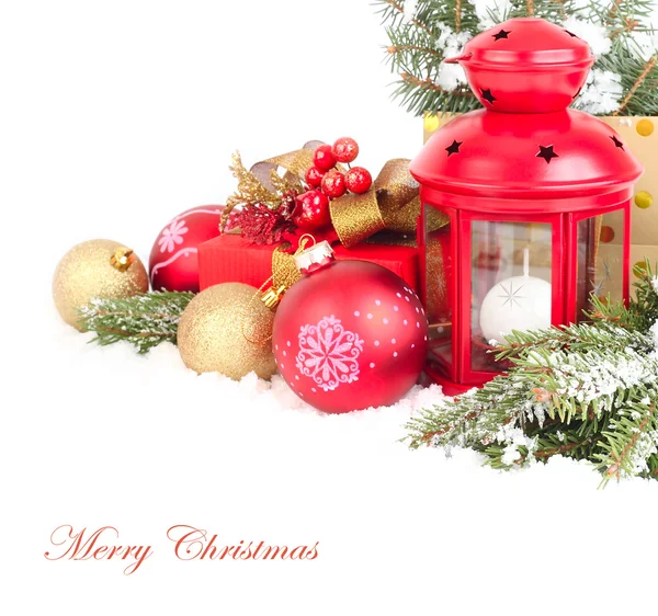 Composição de Natal com um pequeno castiçal de lâmpada vermelho e bolas de Natal douradas e vermelhas em ramos cobertos de neve de uma árvore de Natal em um contexto branco. Um fundo de Natal com um lugar para o texto . — Fotografia de Stock