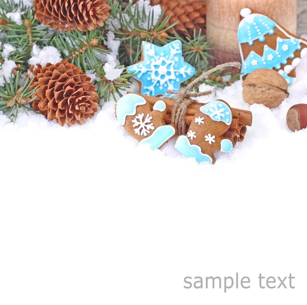 Christmas ginger cookies in blue glaze, nuts and cones on snow on a white background. A Christmas background with a place for the text. — Stock Photo, Image