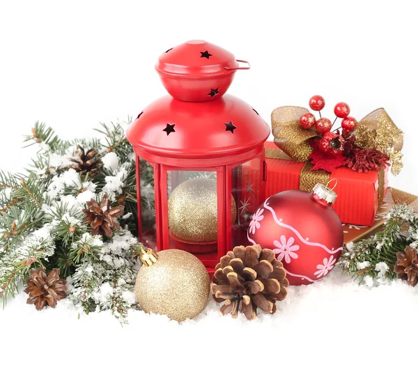 Composição de Natal com um pequeno castiçal de lâmpada vermelho e bolas de Natal douradas e vermelhas em ramos cobertos de neve de uma árvore de Natal em um contexto branco. Um fundo de Natal com um lugar para o texto . — Fotografia de Stock