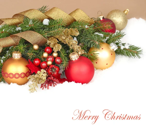 Composición navideña con bolas y cintas de Navidad doradas y rojas sobre ramas cubiertas de nieve de un árbol de Navidad sobre un fondo blanco. Un fondo navideño con un lugar para el texto . — Foto de Stock