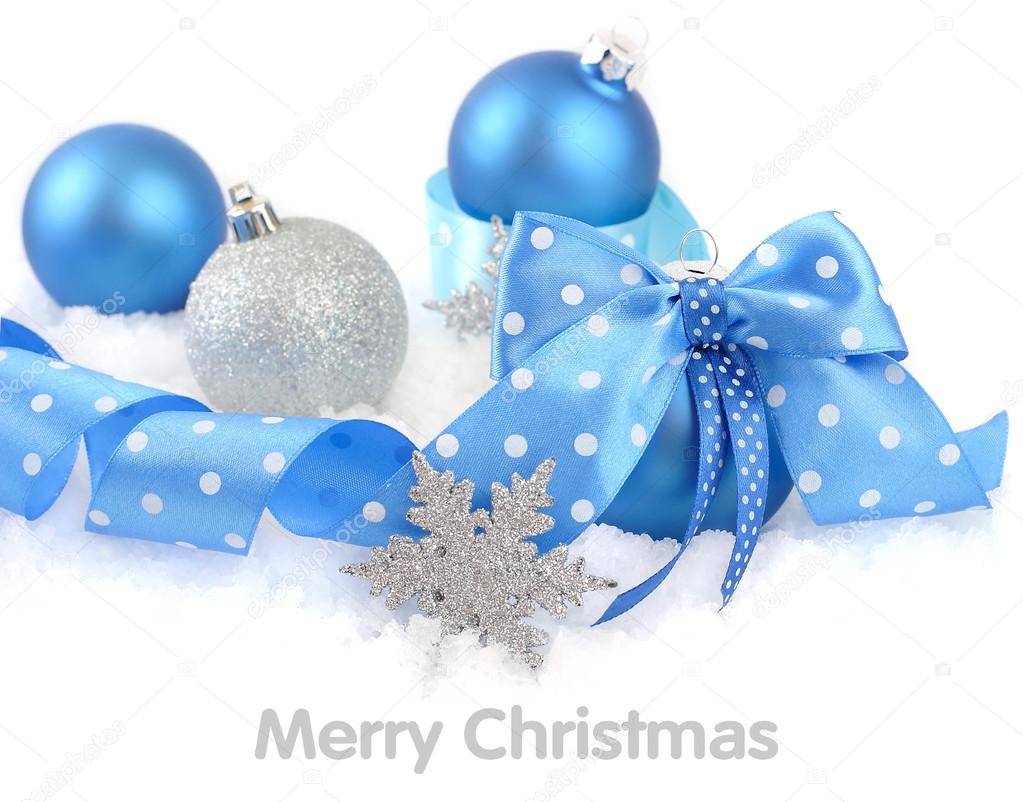 Christmas ball with a blue bow on snow on a white background. A Christmas background with a place for the text.