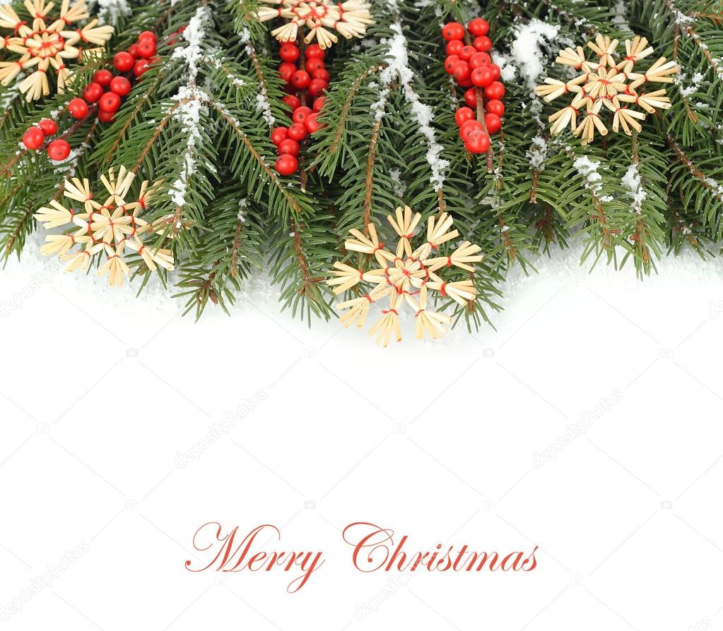 Straw snowflakes and red berries on snow-covered branches of a Christmas tree on a white background. Top view. A Christmas background with a place for the text.