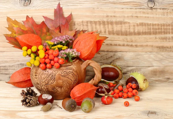 Осенний фон с листьями, каштанами и горным пеплом с местом для текста. Осенняя композиция на деревянном фоне . — стоковое фото