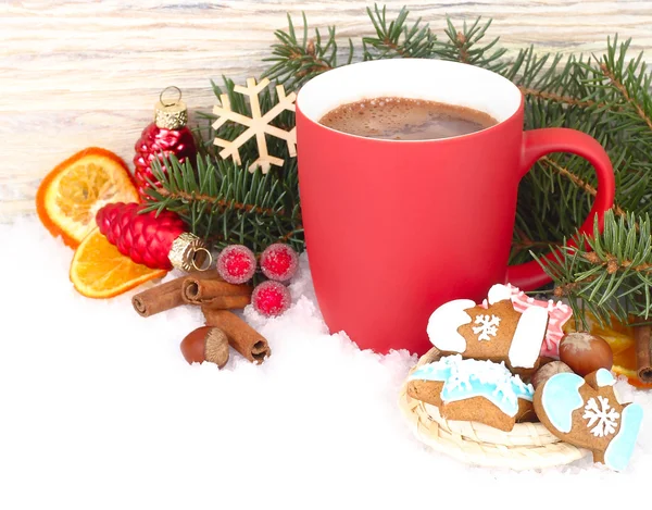 Červený hrnek horké čokolády, skořice a zázvor cookies na sněhu na bílém pozadí. Vánoční pozadí s místem pro text. — Stock fotografie