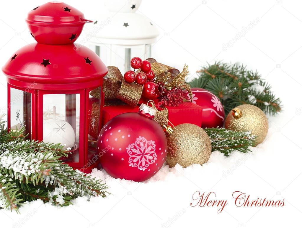 Christmas composition with a red small lamp candlestick and golden and red Christmas balls on snow-covered branches of a Christmas tree on a white background. A Christmas background with a place for the text.